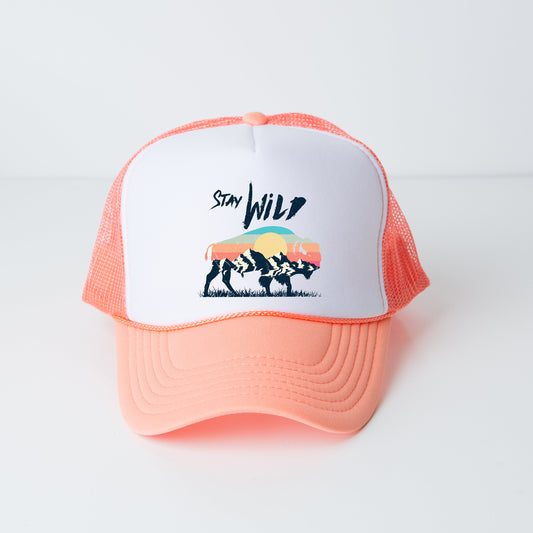 a pink and white trucker hat with the words stay wild on it