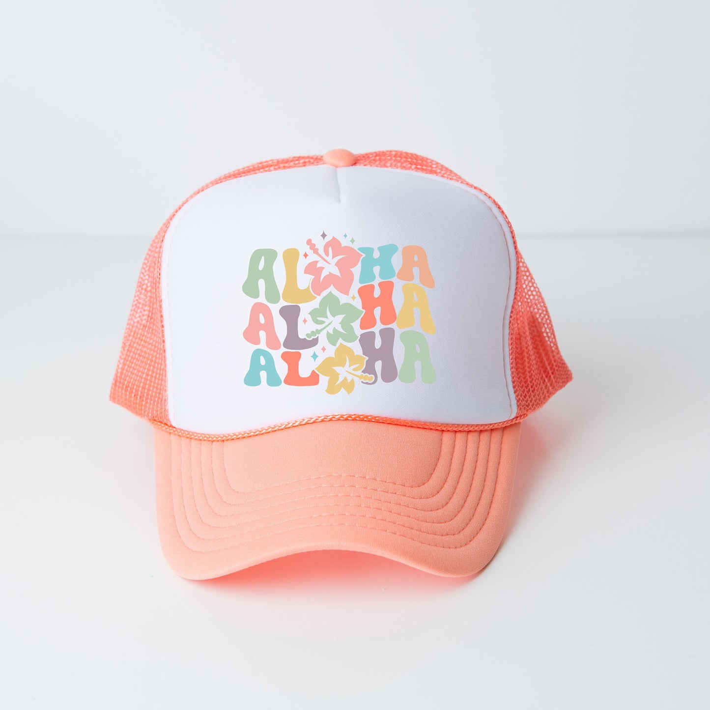 a pink and white trucker hat with the words aloha on it