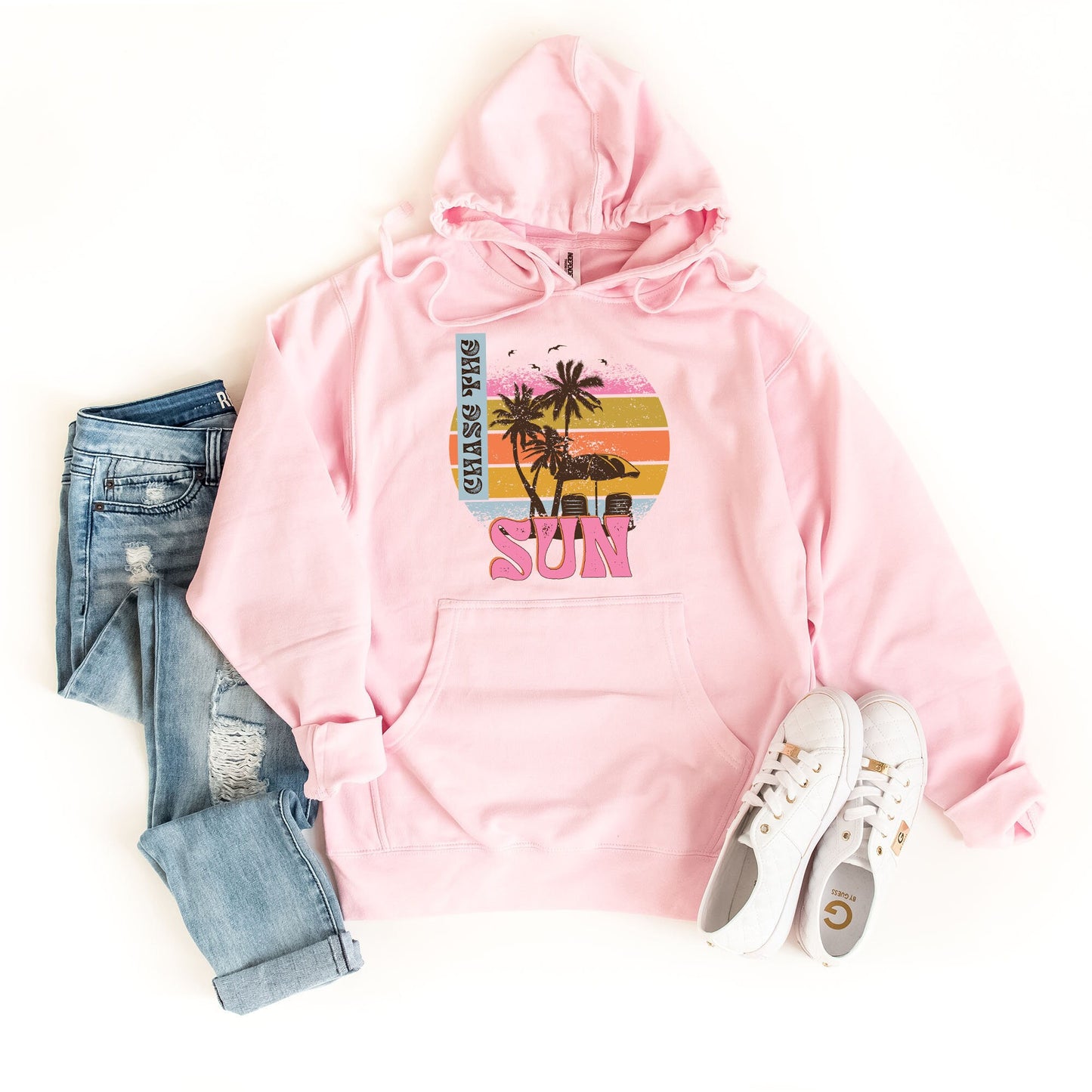 a pink hoodie with a palm tree on it and a pair of jeans