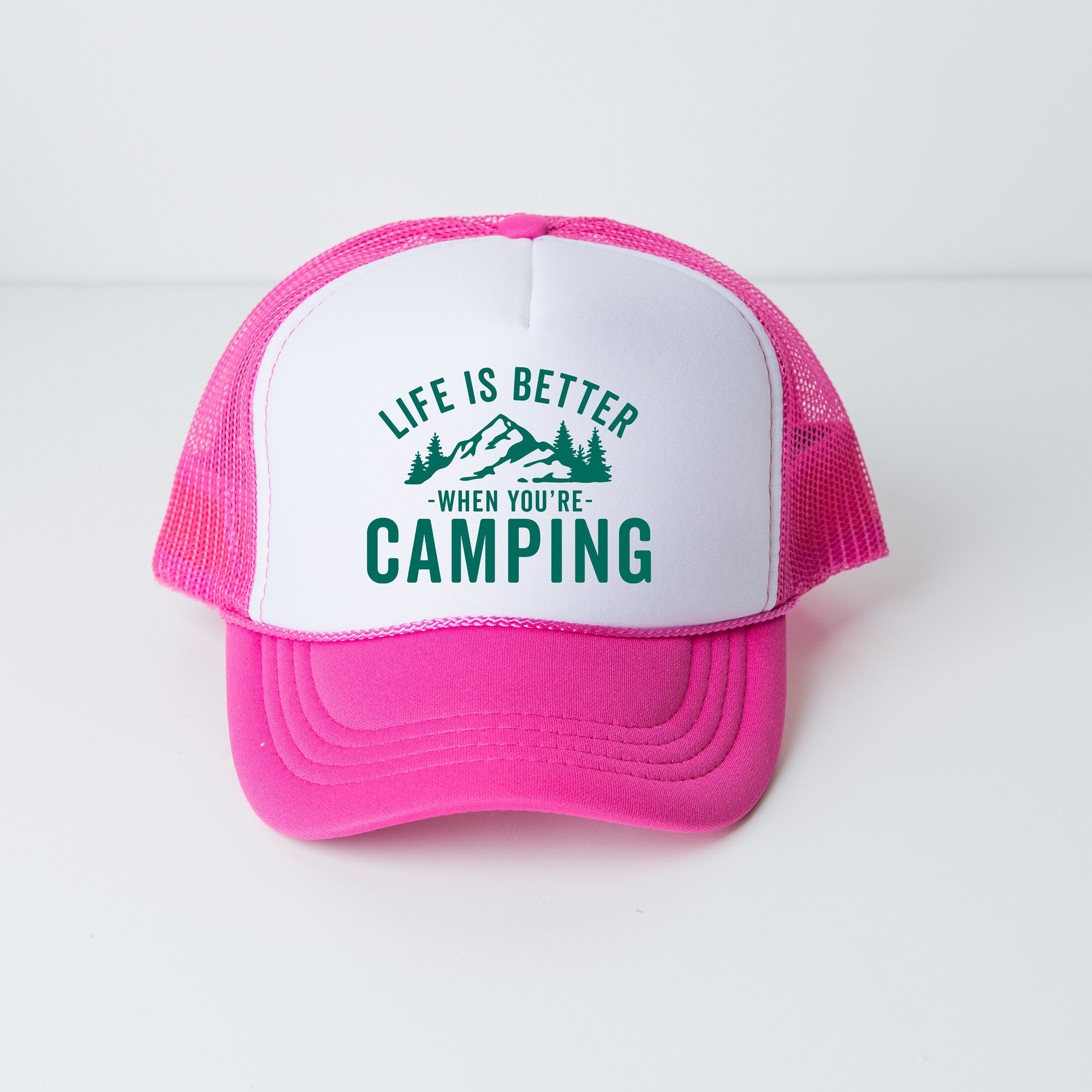 a pink and white trucker hat that says life is better when you're
