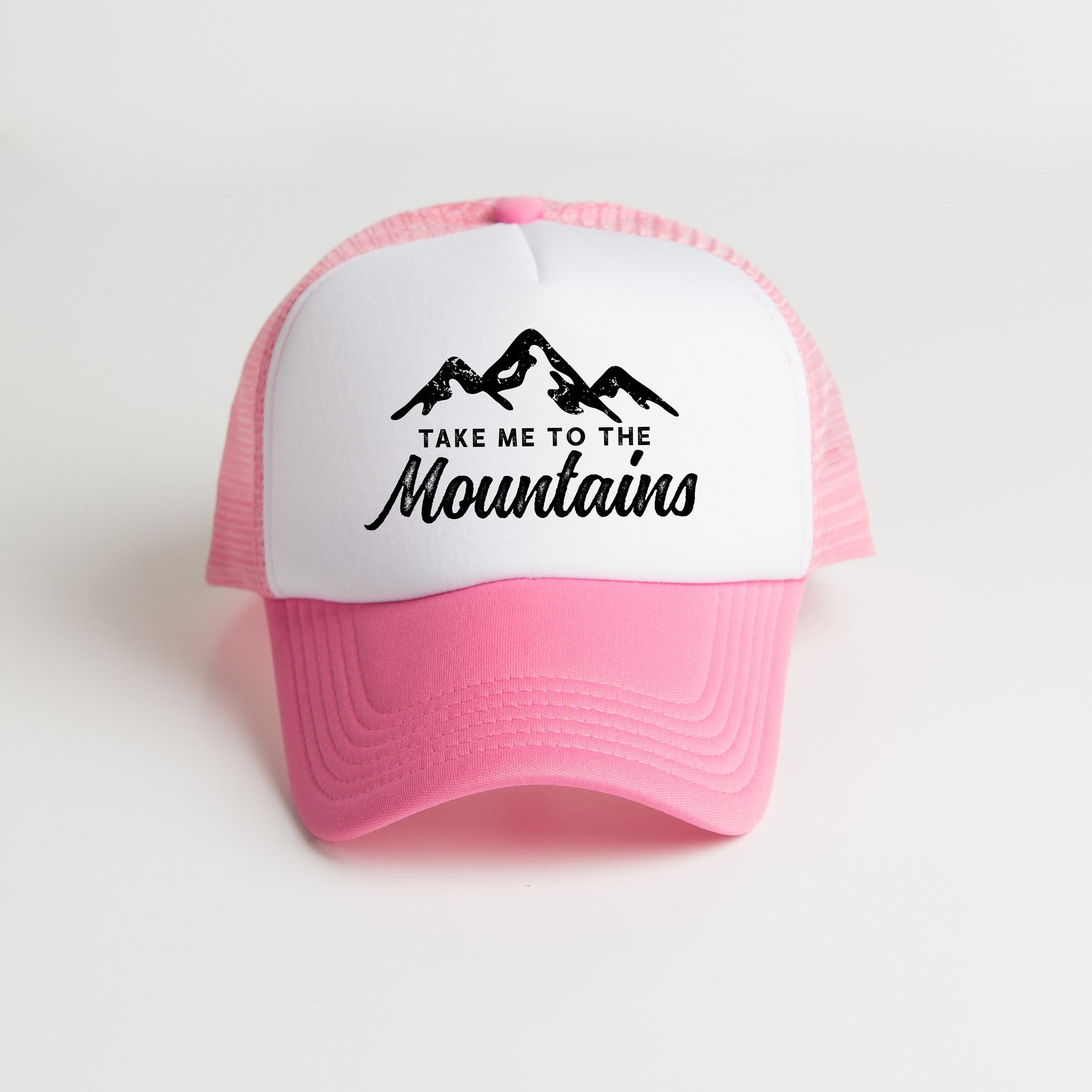 a pink and white trucker hat that says take me to the mountains