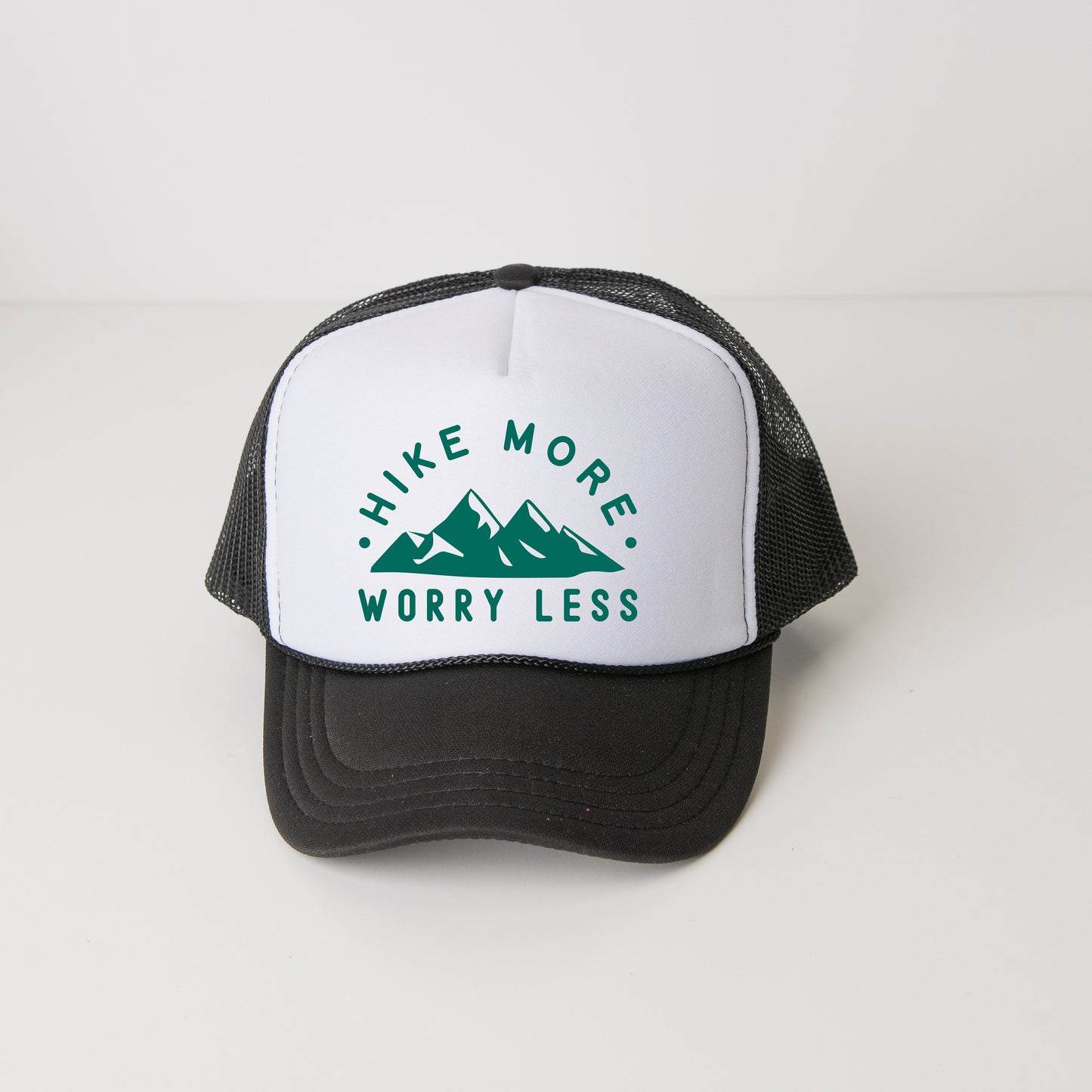 a black and white trucker hat with the words hike more worry less on it