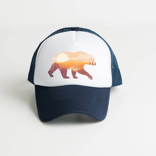 a white and blue hat with a brown bear on it
