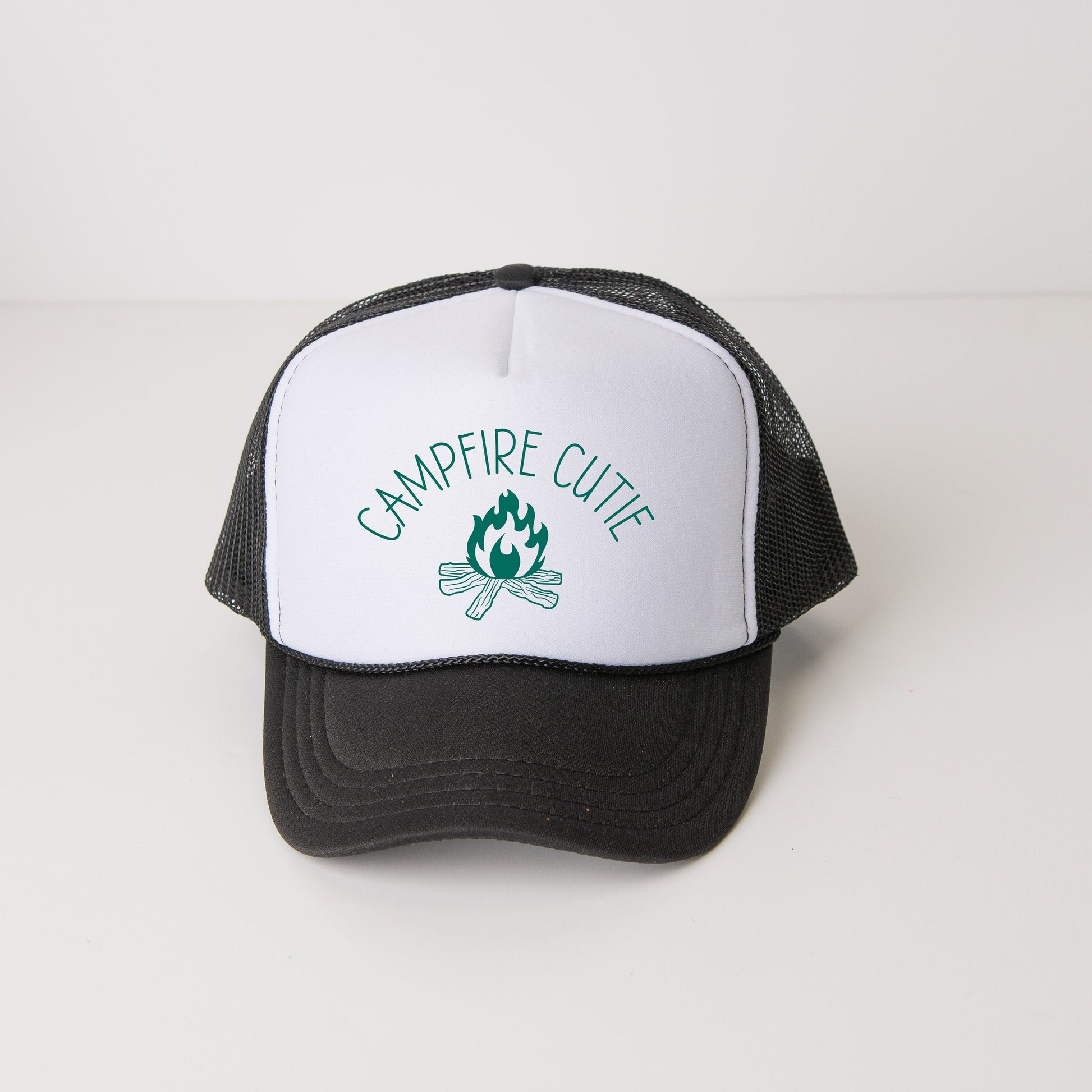 a black and white trucker hat with a campfire cute logo