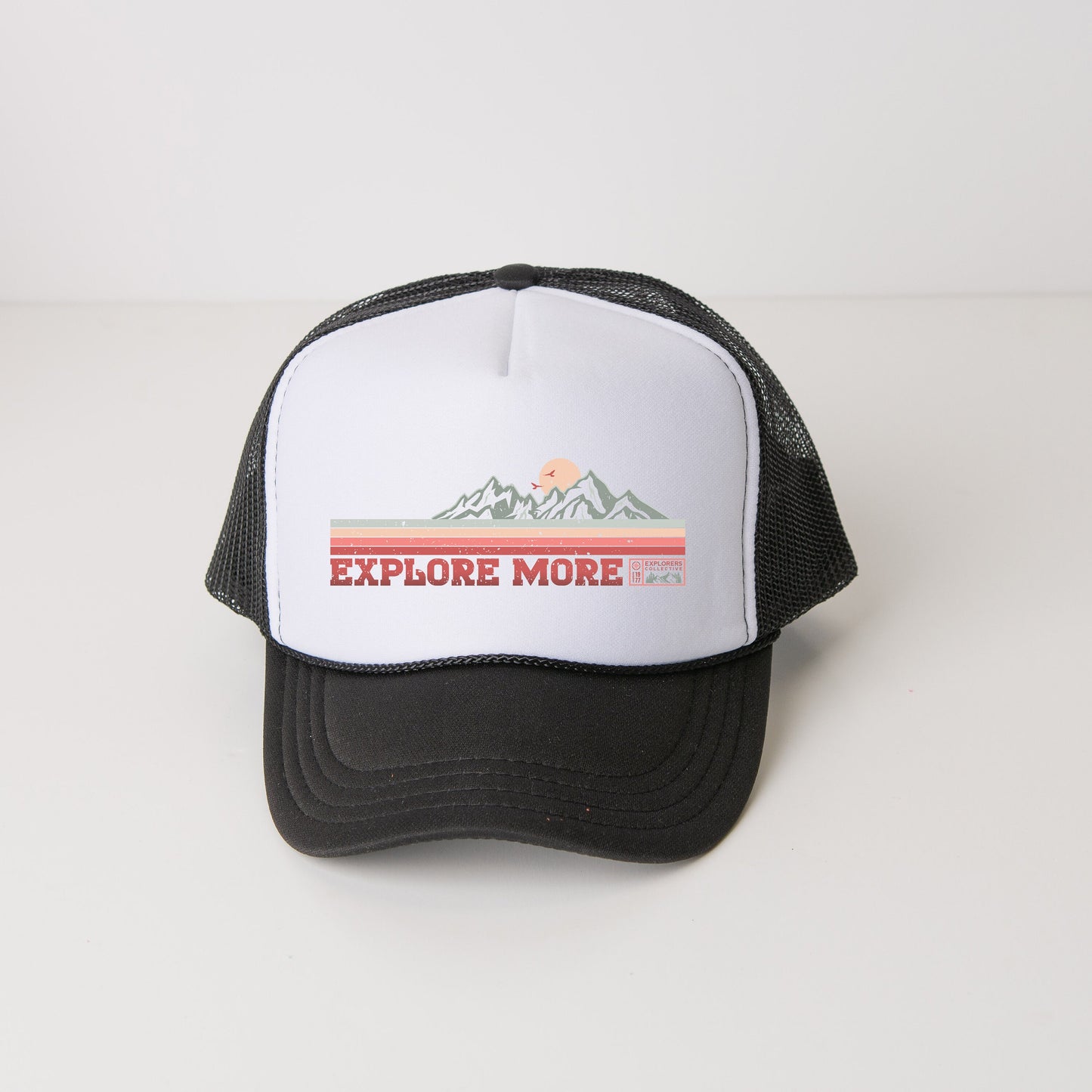 a black and white trucker hat with the words explore more on it