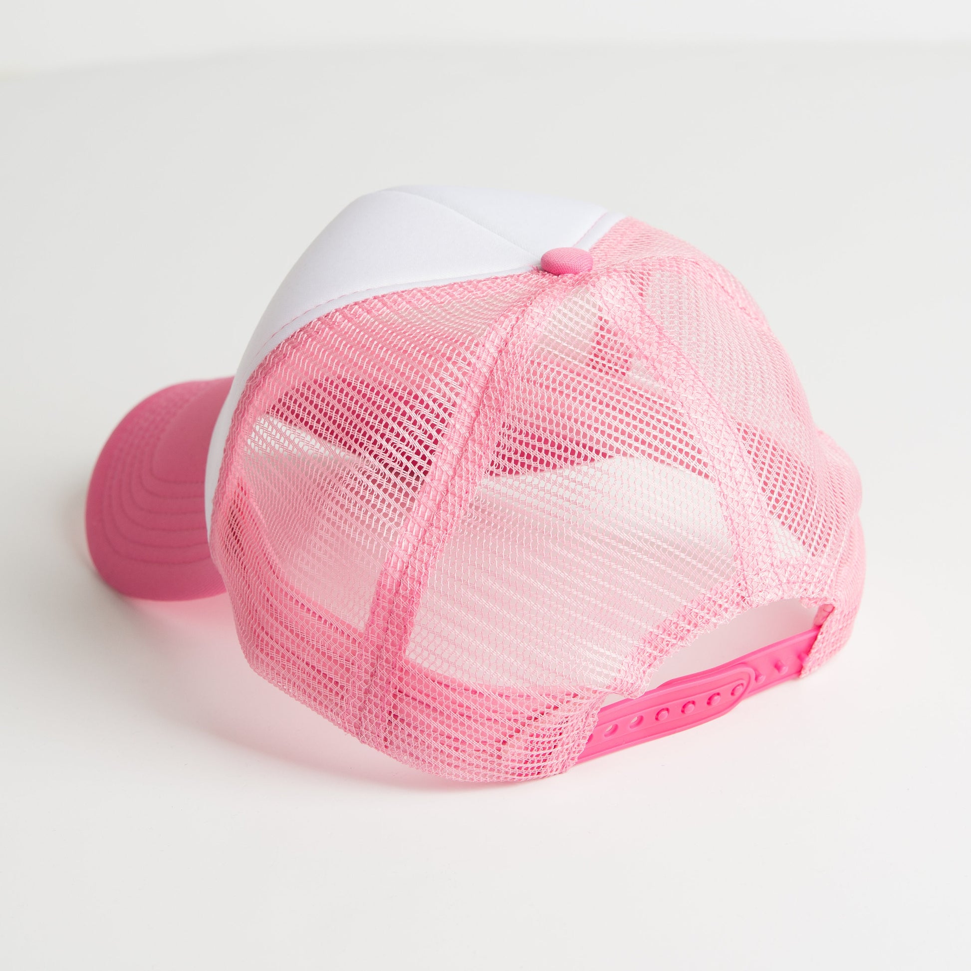 a pink and white hat on a white surface